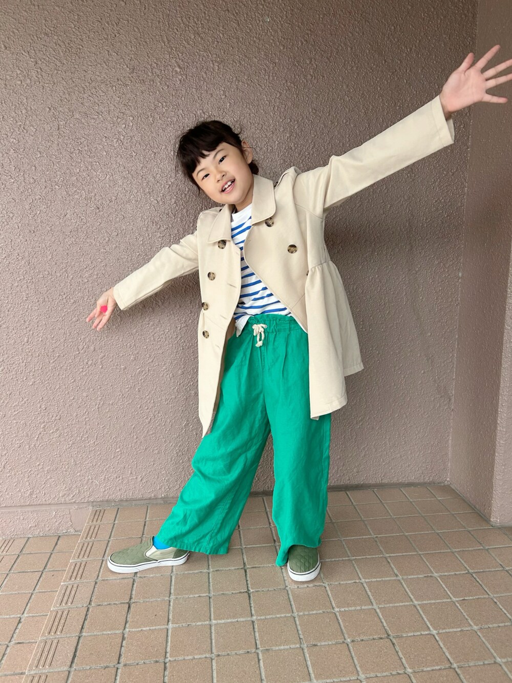 ブルー系のTシャツ/カットソー、ベージュ系のトレンチコート、グリーン系のパンツを着用したキッズの春コーディネートの4枚目の写真