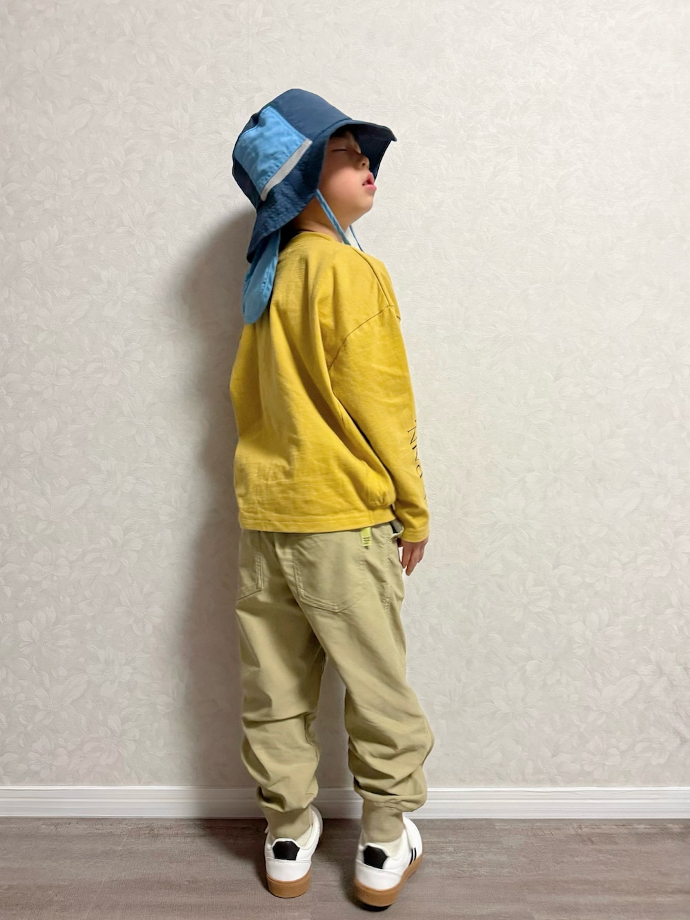 イエロー系のTシャツ/カットソー、ベージュ系のその他パンツ、ブラック系のスニーカーを着用したキッズの冬コーディネートの5枚目の写真