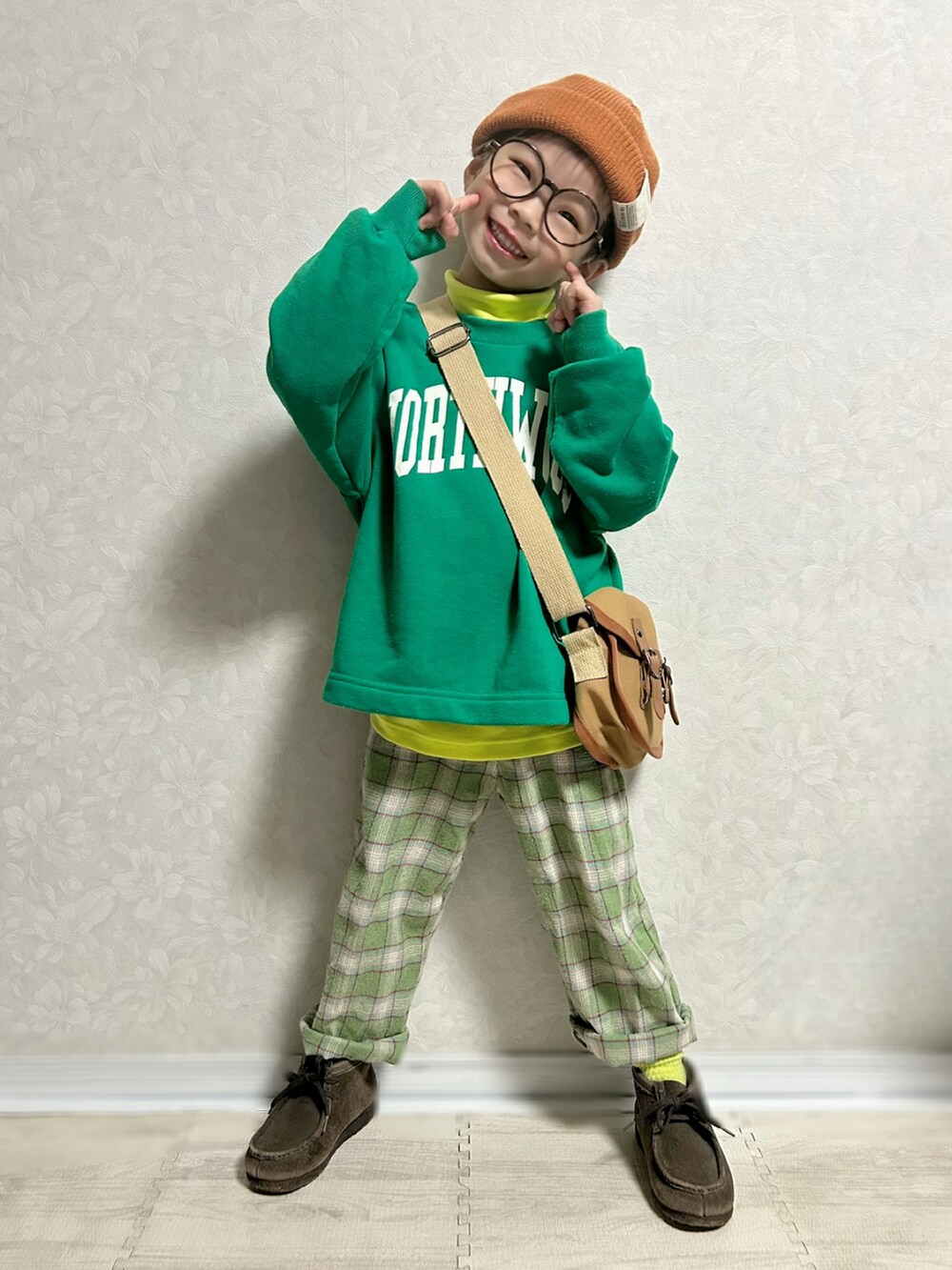 イエロー系のTシャツ/カットソー、グリーン系のスウェット、ブラウン系のショルダーバッグを着用したキッズの冬コーディネートの2枚目の写真