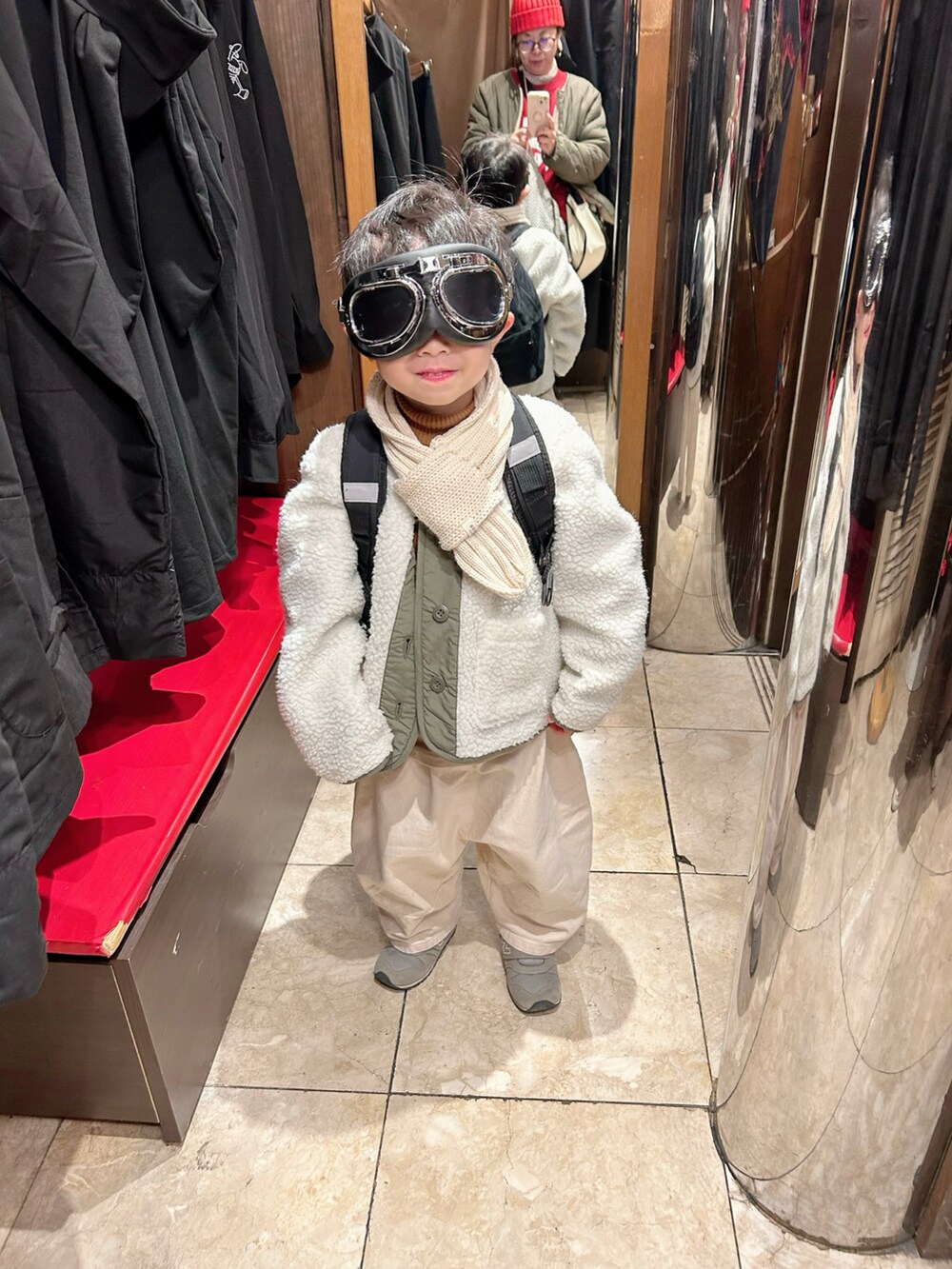 イエロー系のニット/セーター、グリーン系のノーカラージャケット、ベージュ系のチノパンツを着用したキッズの冬コーディネートの5枚目の写真