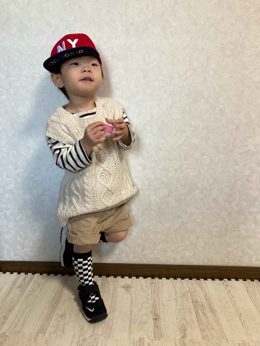 ホワイト系のベスト、ベージュ系のパンツ、ブラック系のスニーカーを着用したキッズの春コーディネートの3枚目の写真