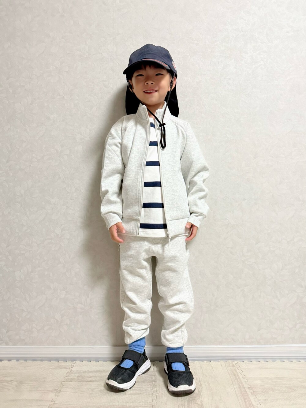 ブラック系のサンダル、ホワイト系のTシャツ/カットソー、グレー系のノーカラージャケットを着用したキッズの夏コーディネートの2枚目の写真