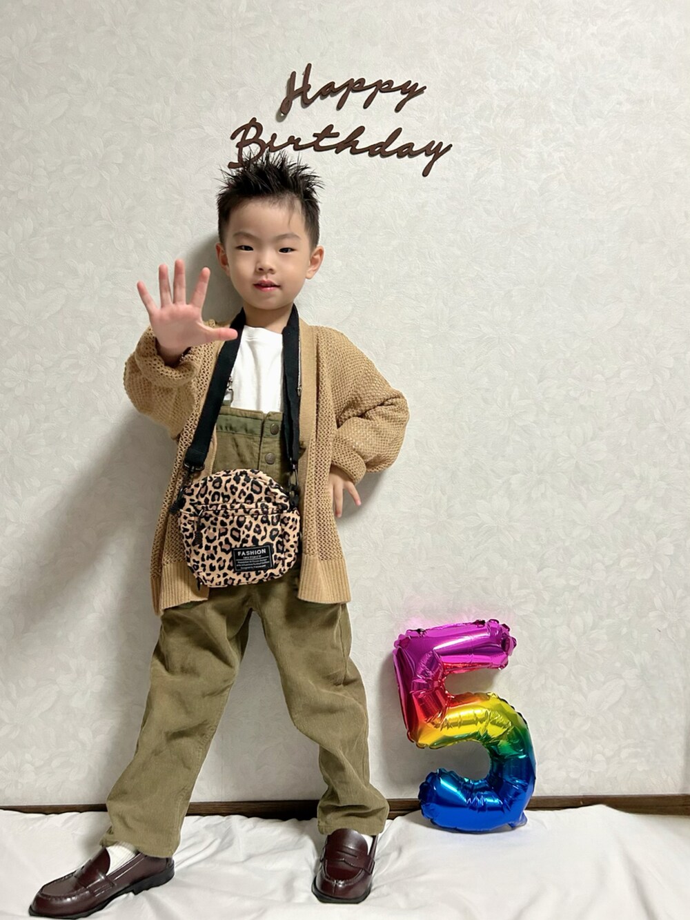 ホワイト系のTシャツ/カットソー、ブラウン系のカーディガン/ボレロ、グリーン系のサロペット/オーバーオールを着用したキッズの秋コーディネートの2枚目の写真