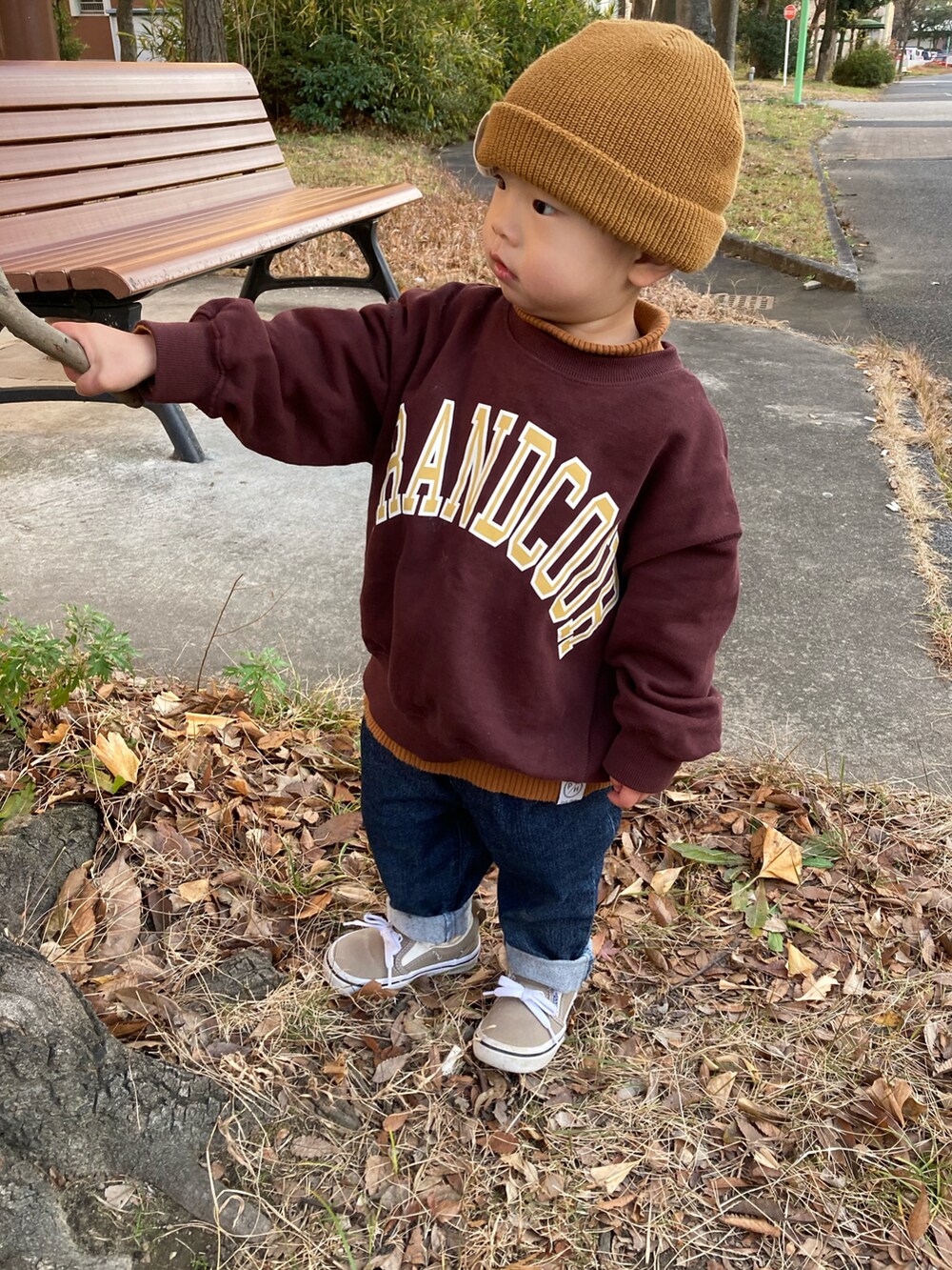 イエロー系のニット/セーター、ブラウン系のスウェット、ブルー系のデニムパンツを着用したキッズの冬コーディネートの3枚目の写真