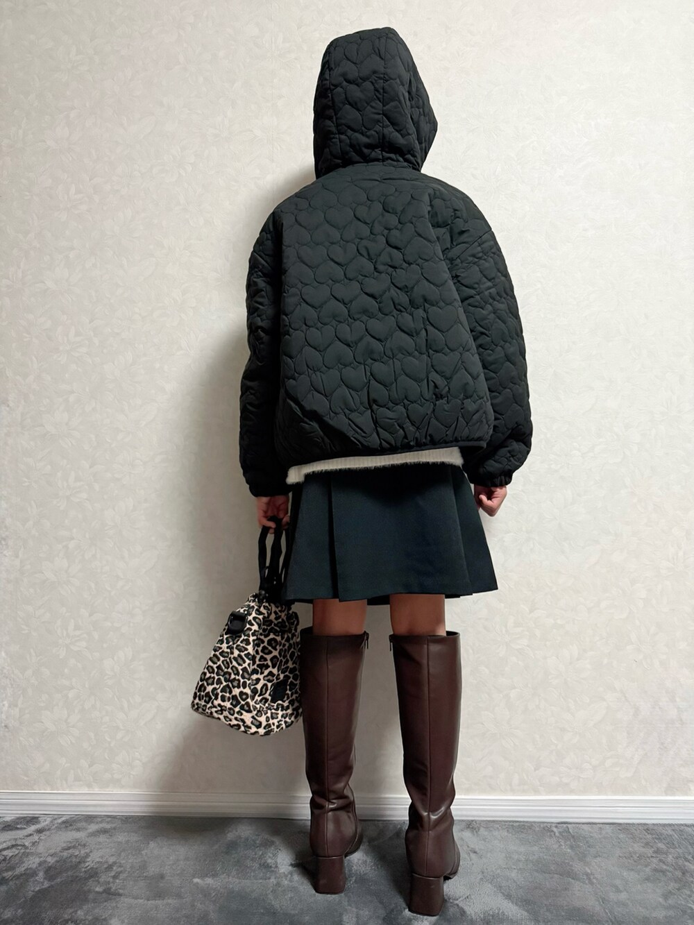 ブラウン系のブーツ、ホワイト系のニット/セーター、ブラック系のジャケット/アウターを着用したキッズの秋コーディネートの3枚目の写真