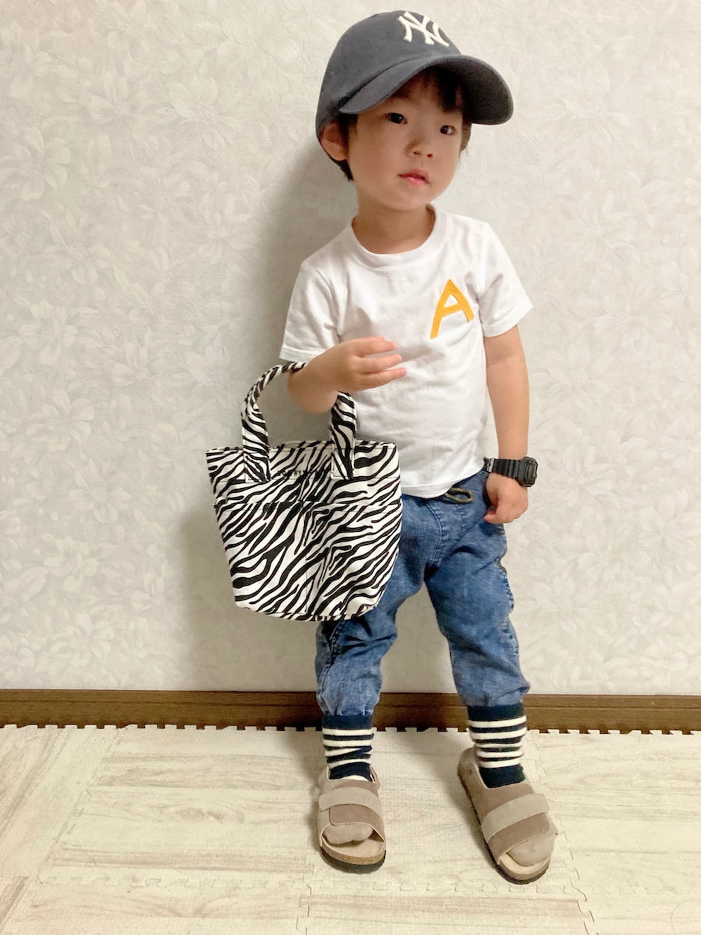 グレー系のカーディガン/ボレロ、ブルー系のデニムパンツ、その他のトートバッグを着用したキッズの秋コーディネートの4枚目の写真