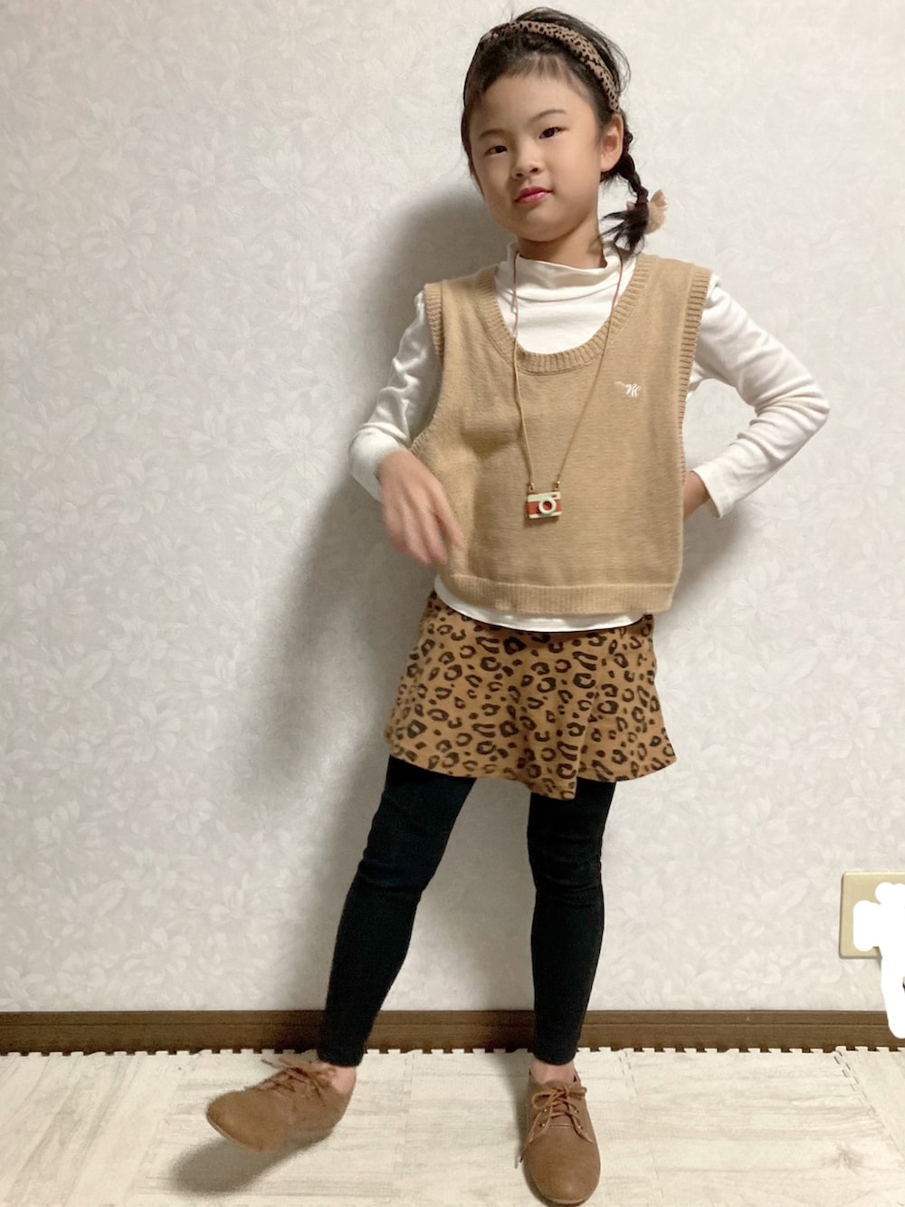 ホワイト系のTシャツ/カットソー、ベージュ系のベスト、ブラウン系のスカートを着用したキッズの秋コーディネートの3枚目の写真
