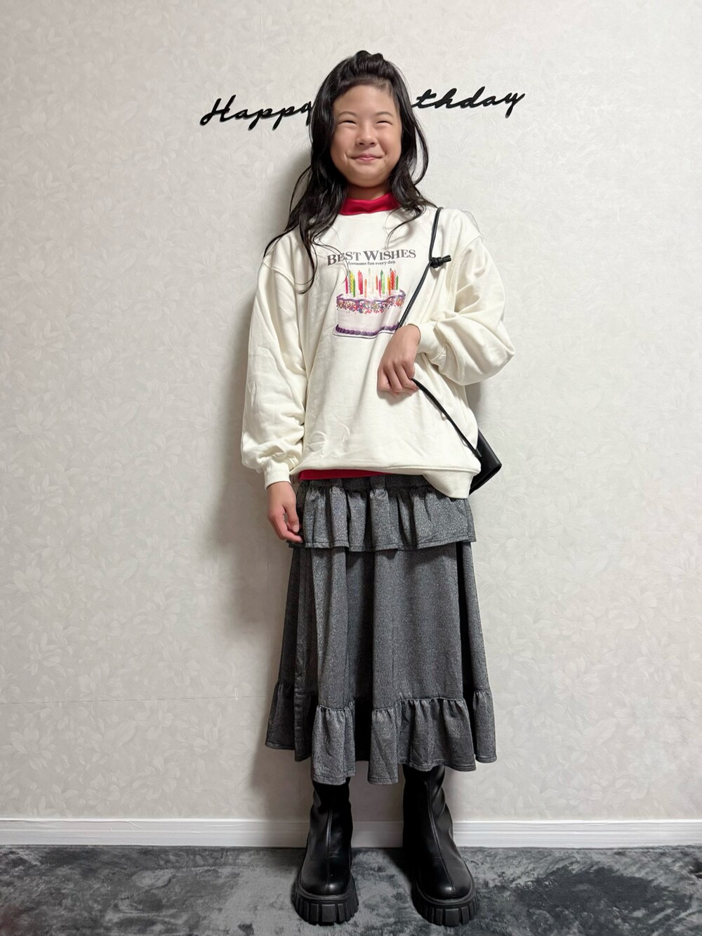 ブラック系のスカート、ホワイト系のスウェット、レッド系のTシャツ/カットソーを着用したキッズの秋コーディネートの4枚目の写真