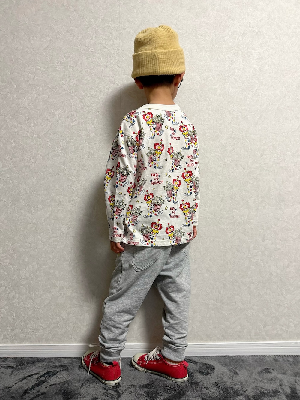 レッド系のスニーカー、ベージュ系のTシャツ/カットソー、グレー系のスウェットパンツを着用したキッズの冬コーディネートの5枚目の写真