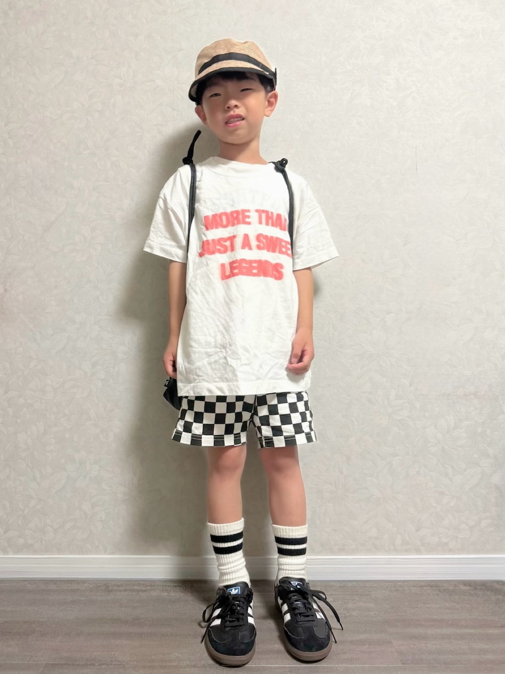 ブラック系のバックパック/リュック、ブラック系のスニーカー、ホワイト系のTシャツ/カットソーを着用したキッズの夏コーディネートの2枚目の写真