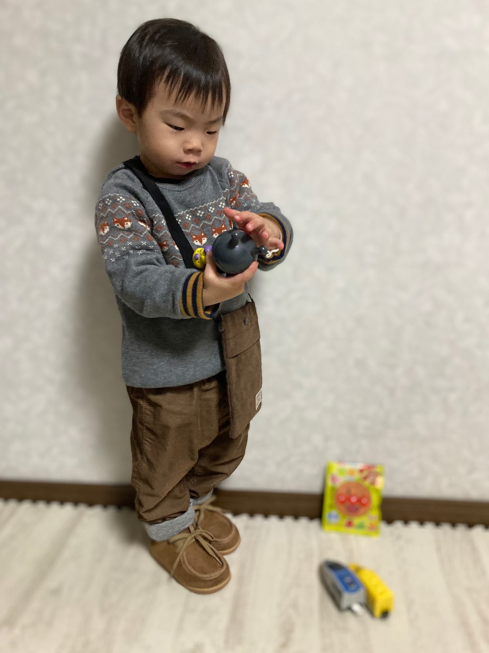 ブラウン系のTシャツ/カットソー、グレー系のニット/セーター、ブラウン系のショルダーバッグを着用したキッズの冬コーディネートの2枚目の写真