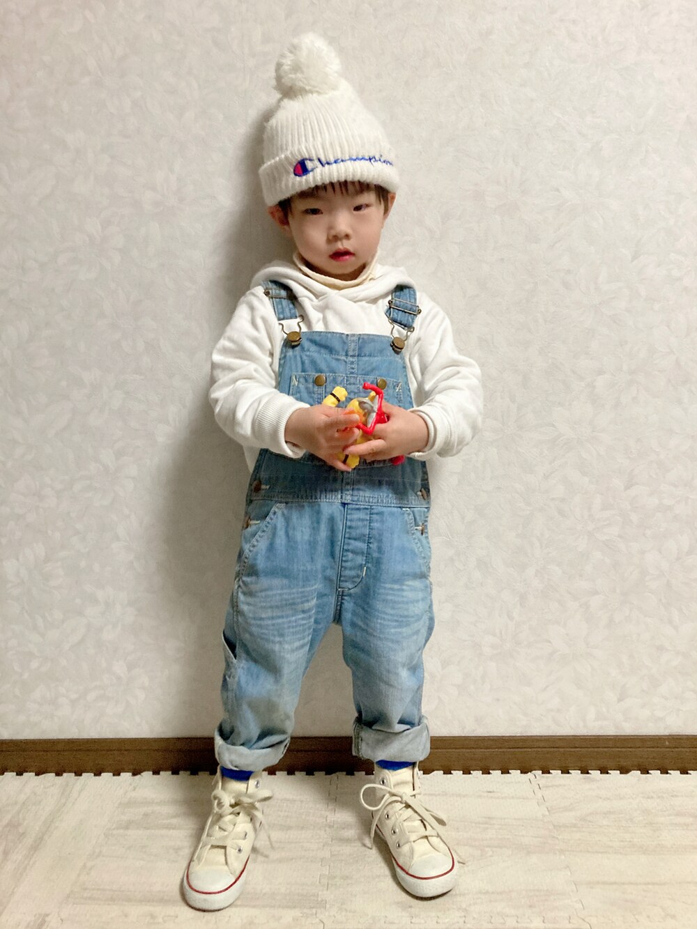 ホワイト系のパーカー、ホワイト系のニット/セーター、ブルー系のダウンベストを着用したキッズの冬コーディネートの2枚目の写真