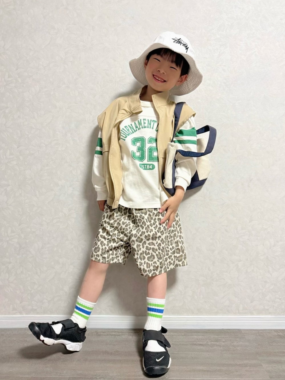 ベージュ系のその他パンツ、ホワイト系のショルダーバッグ、ブラック系のスニーカーを着用したキッズの春コーディネートの2枚目の写真