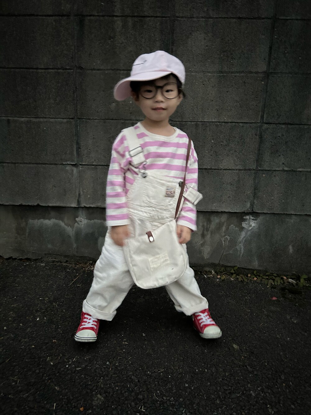 ピンク系のTシャツ/カットソー、ホワイト系のサロペット/オーバーオール、ホワイト系のショルダーバッグを着用したキッズの春コーディネートの3枚目の写真