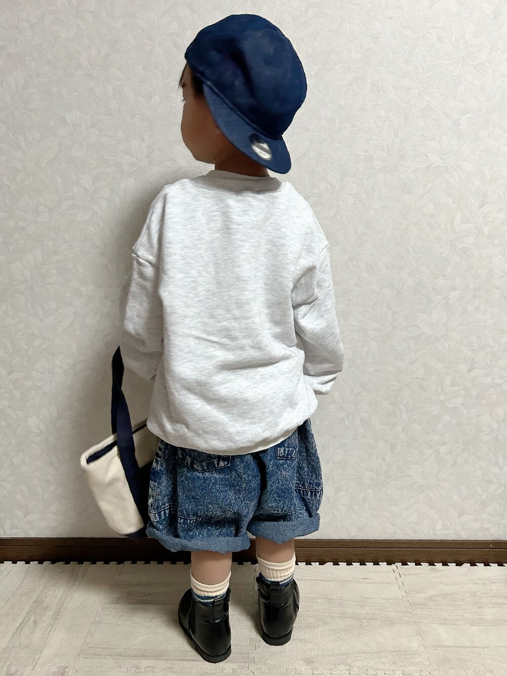 グレー系のスウェット、ブルー系のデニムパンツ、ブラック系のブーツを着用したキッズの秋コーディネートの5枚目の写真