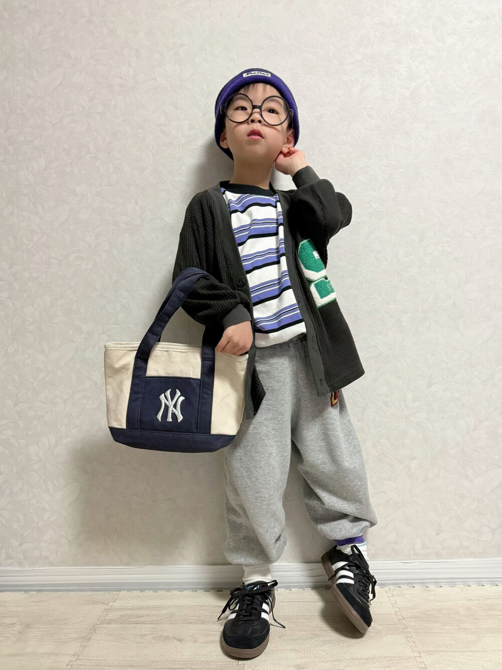 パープル系のTシャツ/カットソー、ブラック系のカーディガン/ボレロ、グレー系のスウェットパンツを着用したキッズの春コーディネートの4枚目の写真