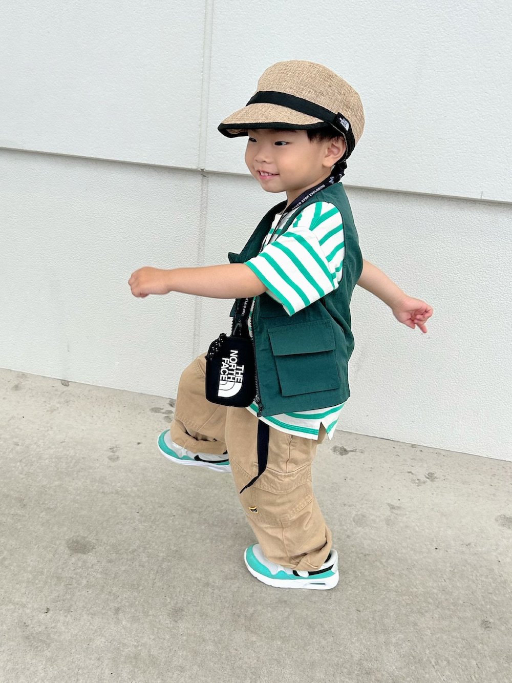 グリーン系のTシャツ/カットソー、グリーン系のベスト、ベージュ系のカーゴパンツを着用したキッズの夏コーディネートの3枚目の写真