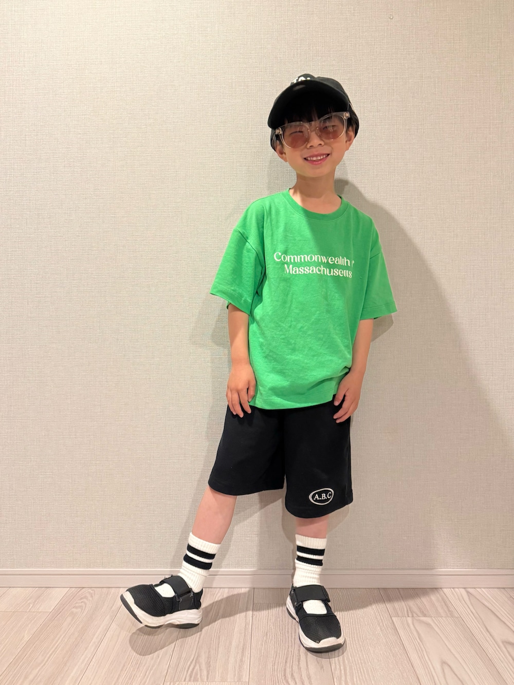 グリーン系のTシャツ/カットソー、ブラック系のセットアップ、ブラック系のサンダルを着用したキッズの春コーディネートの2枚目の写真