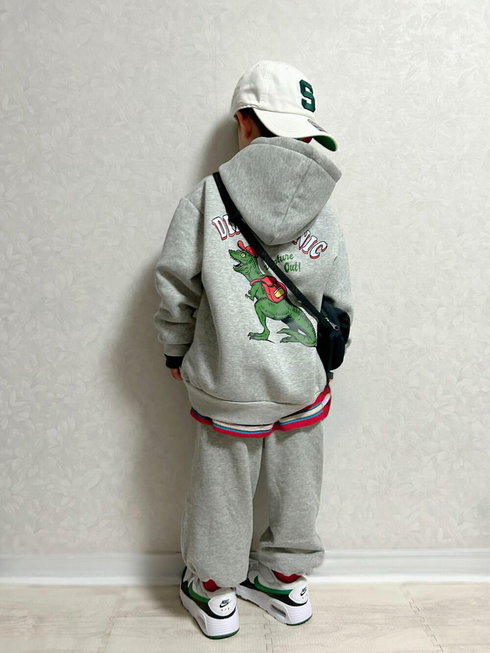 グレー系のパーカー、レッド系のTシャツ/カットソー、グレー系のスウェットパンツを着用したキッズの冬コーディネートの3枚目の写真