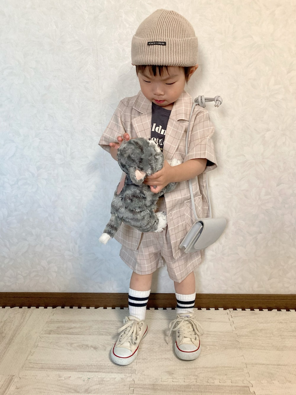 グレー系のTシャツ/カットソー、ベージュ系のセットアップ、ホワイト系のスニーカーを着用したキッズの夏コーディネートの3枚目の写真