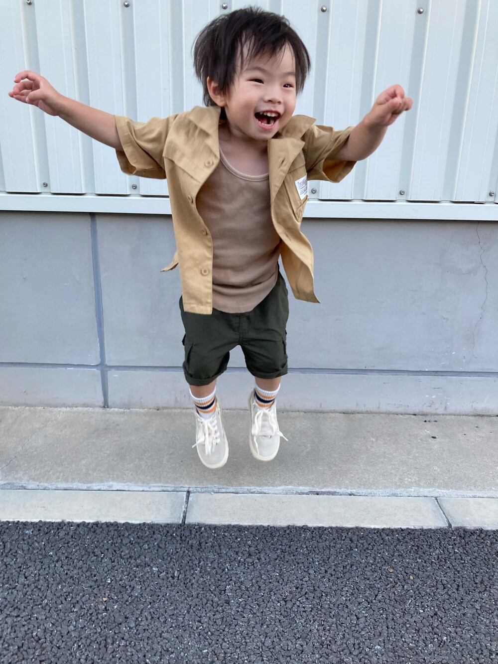 ベージュ系のタンクトップ、イエロー系のシャツ/ブラウス、グリーン系のカーゴパンツを着用したキッズの夏コーディネートの3枚目の写真