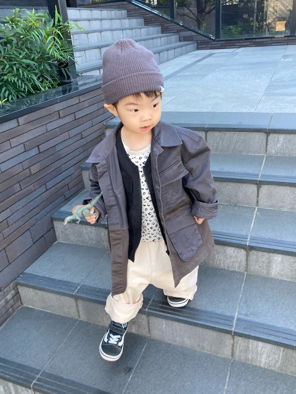 ベージュ系のTシャツ/カットソー、ブラック系のベスト、ベージュ系のチノパンツを着用したキッズの秋コーディネートの3枚目の写真