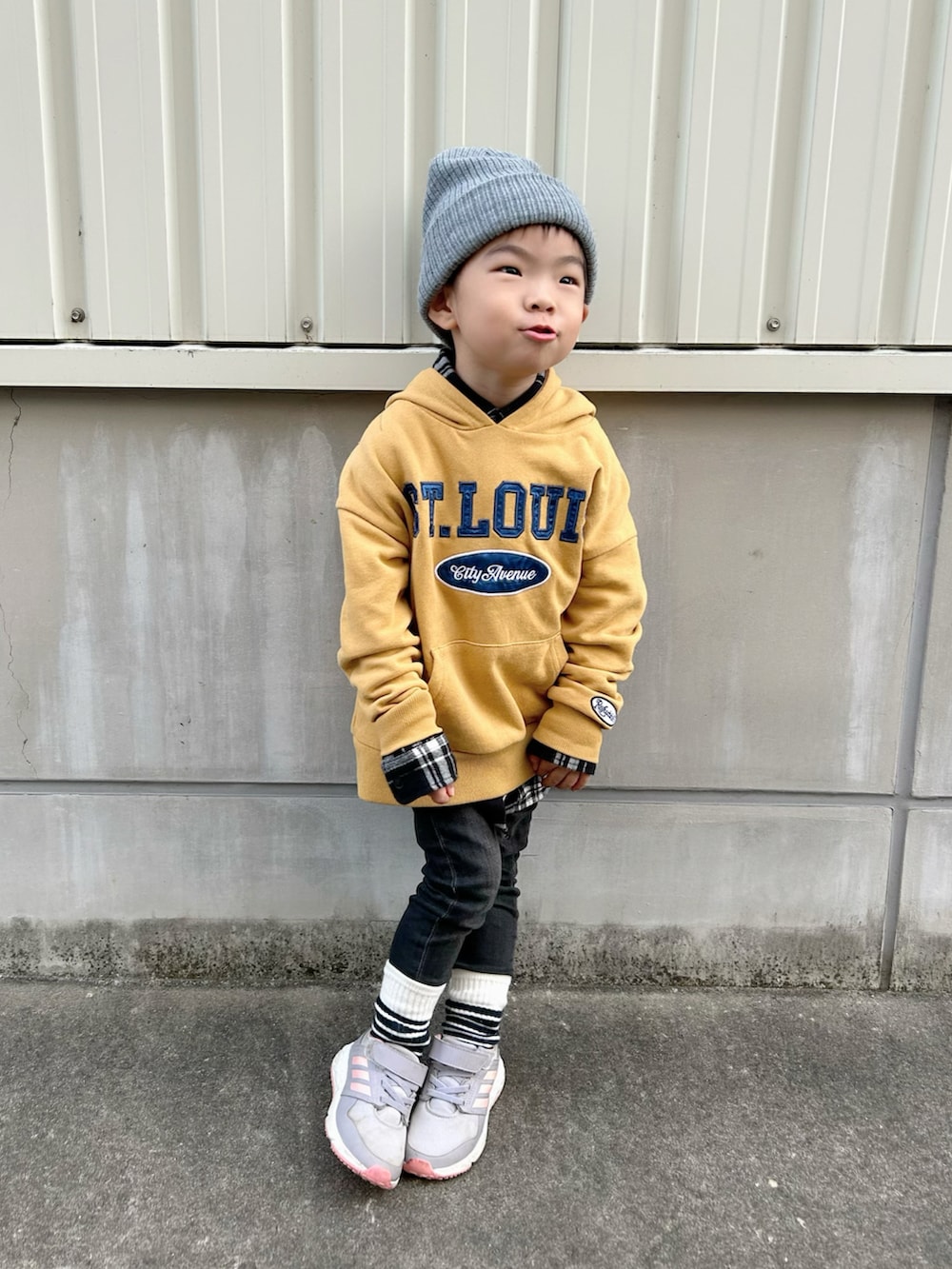 ブラック系のシャツ/ブラウス、イエロー系のパーカー、ブラック系のデニムパンツを着用したキッズの冬コーディネートの4枚目の写真