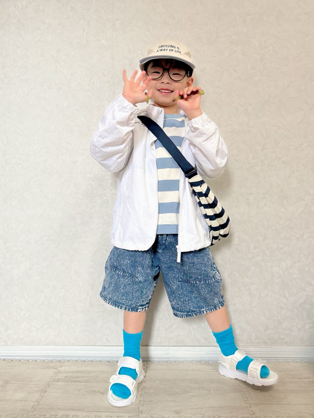 ブルー系のTシャツ/カットソー、ホワイト系のナイロンジャケット、ホワイト系のショルダーバッグを着用したキッズの春コーディネートの4枚目の写真