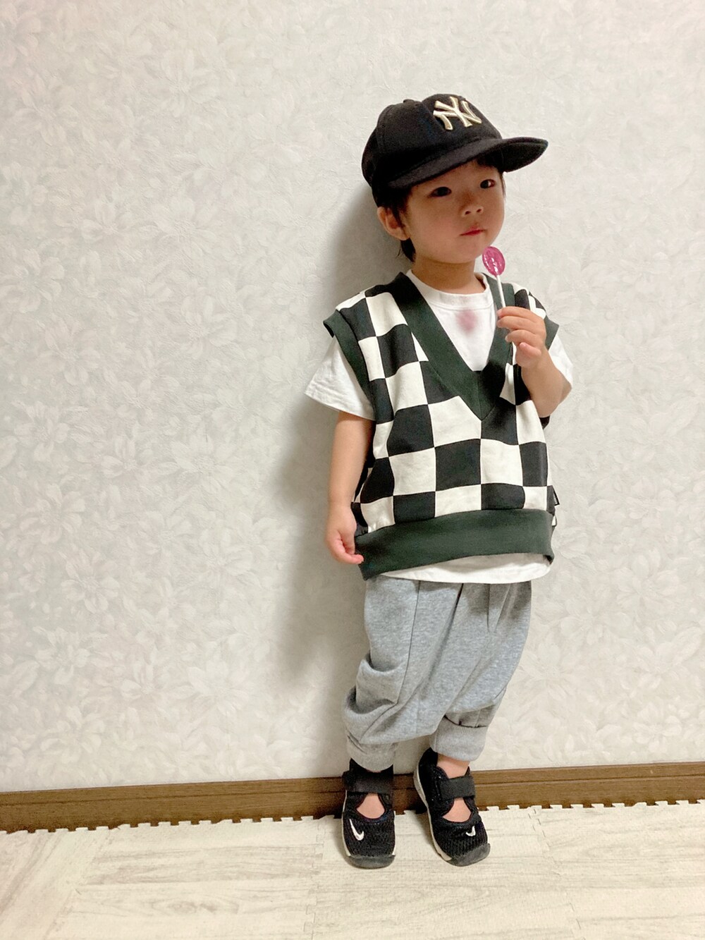 ホワイト系のTシャツ/カットソー、ブラック系のベスト、グレー系のスウェットパンツを着用したキッズの秋コーディネートの5枚目の写真