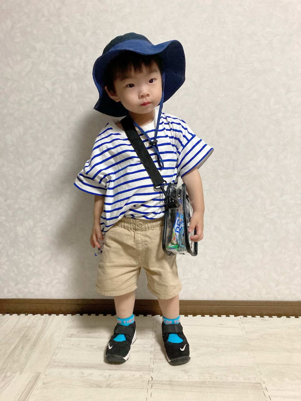 ブルー系のTシャツ/カットソー、その他のショルダーバッグ、ベージュ系のパンツを着用したキッズの夏コーディネートの2枚目の写真