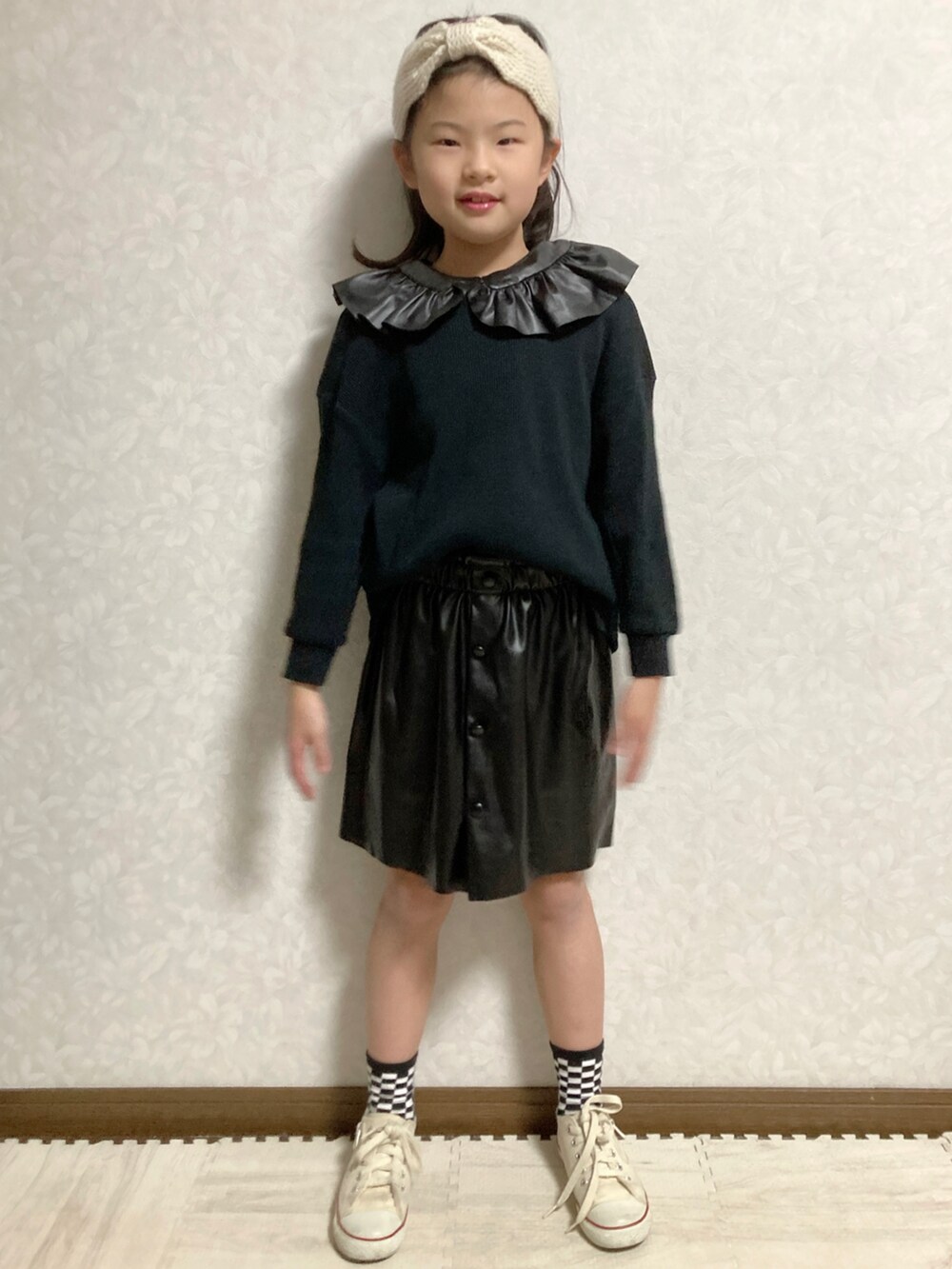 ブラック系のTシャツ/カットソー、ブラック系のスカート、ホワイト系のスニーカーを着用したキッズの冬コーディネートの4枚目の写真