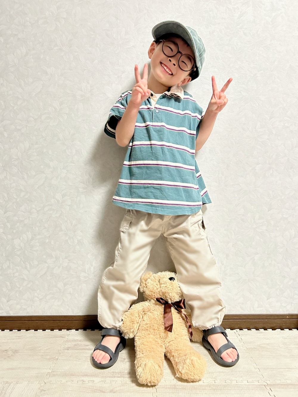グリーン系のポロシャツ、ベージュ系のカーゴパンツ、ブラック系のサンダルを着用したキッズの夏コーディネートの2枚目の写真