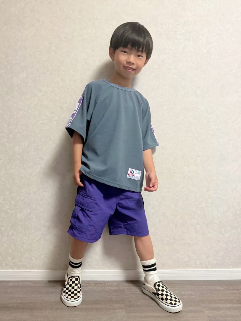 ブルー系のセットアップ、パープル系のカーゴパンツ、ブラック系のスリッポンを着用したキッズの夏コーディネートの4枚目の写真
