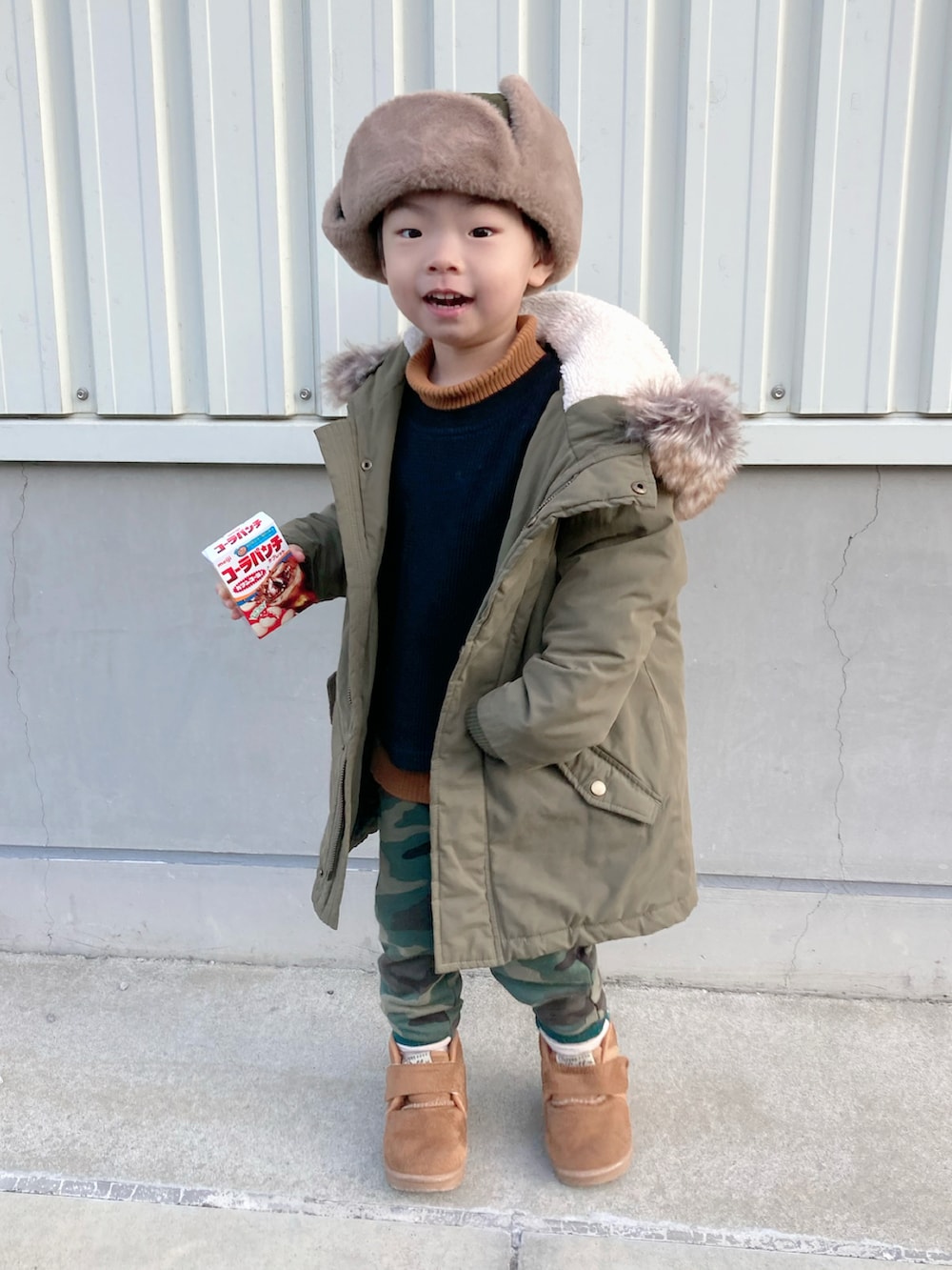 イエロー系のニット/セーター、ブラック系のTシャツ/カットソー、グリーン系のモッズコートを着用したキッズの冬コーディネートの3枚目の写真