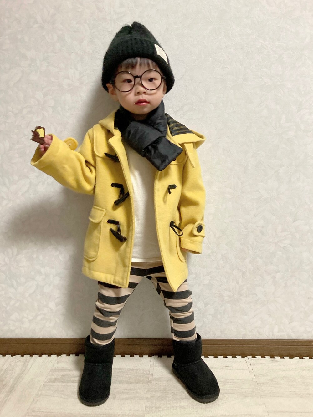 ホワイト系のニット/セーター、イエロー系のダッフルコート、ブラック系のその他パンツを着用したキッズの冬コーディネートの2枚目の写真