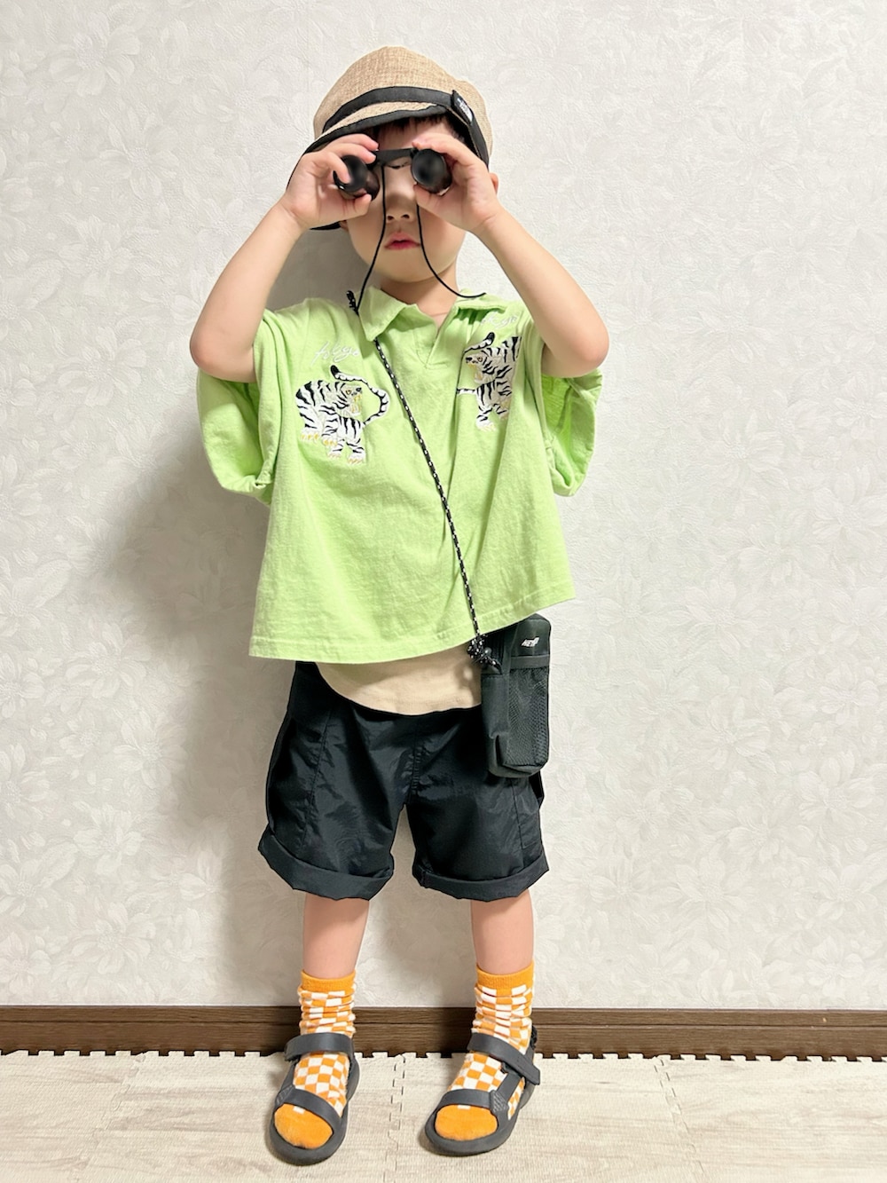 ベージュ系のタンクトップ、グリーン系のポロシャツ、ブラック系のカーゴパンツを着用したキッズの夏コーディネートの2枚目の写真