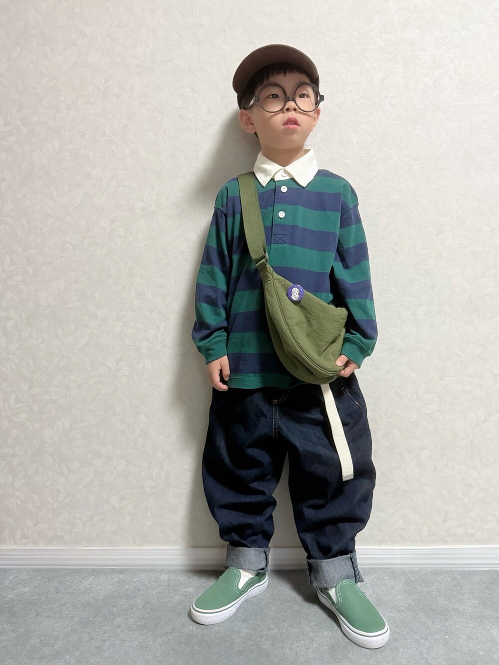 グリーン系のスリッポン、グリーン系のポロシャツ、ブルー系のデニムパンツを着用したキッズの秋コーディネートの3枚目の写真