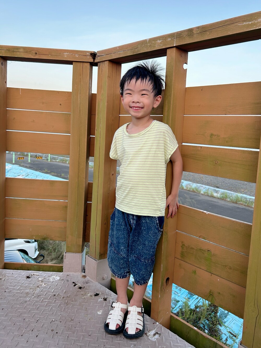 イエロー系のTシャツ/カットソー、ブルー系のデニムパンツ、ホワイト系のサンダルを着用したキッズの夏コーディネートの3枚目の写真