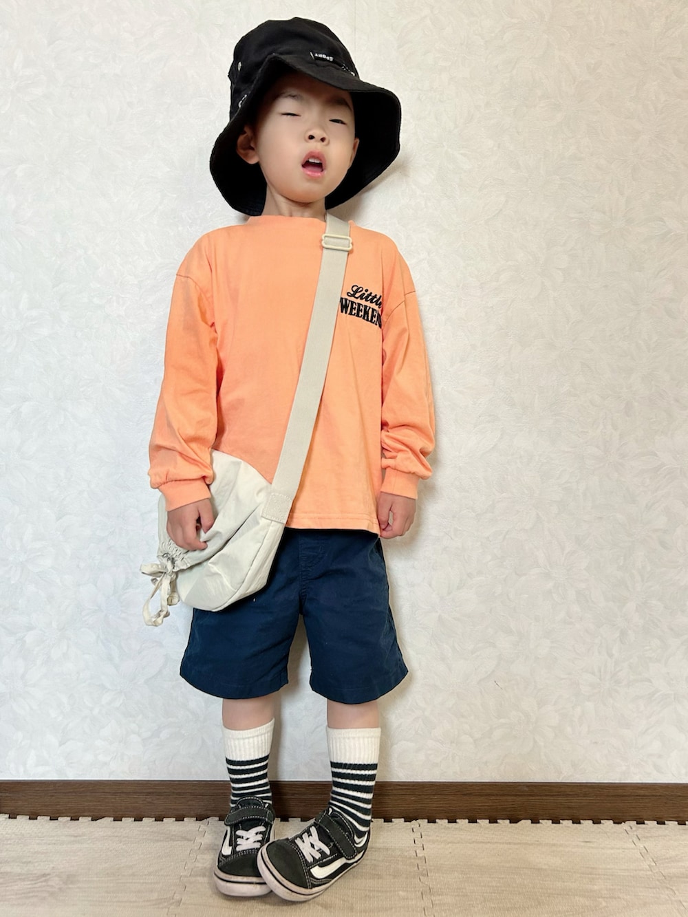 オレンジ系のTシャツ/カットソー、ホワイト系のショルダーバッグ、ベージュ系のベストを着用したキッズの春コーディネートの5枚目の写真