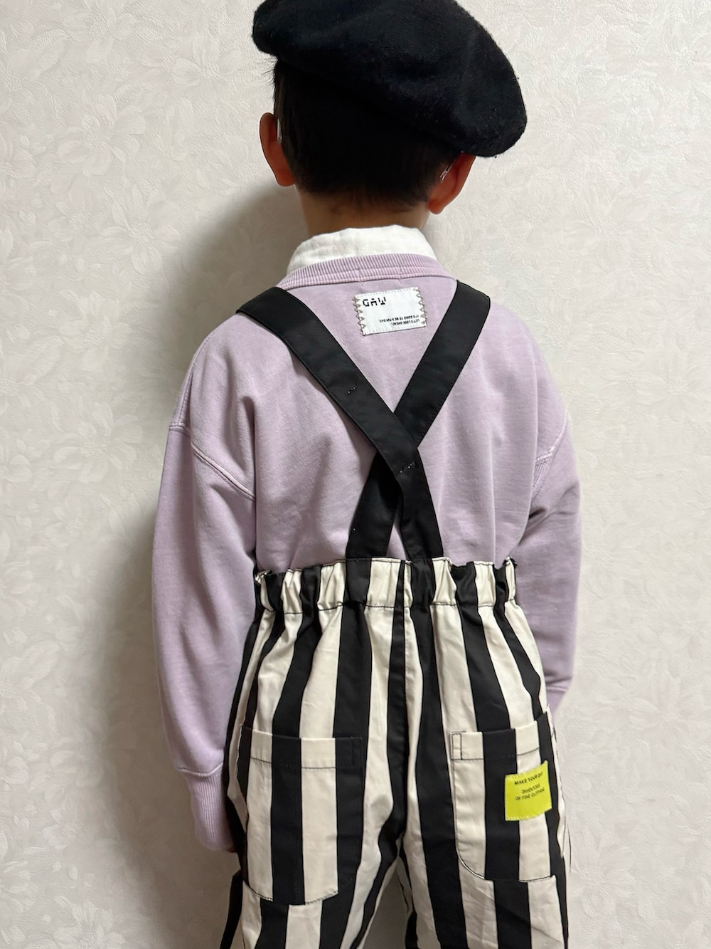 パープル系のスウェット、ブラック系のサロペット/オーバーオール、ホワイト系のシャツ/ブラウスを着用したキッズの冬コーディネートの4枚目の写真