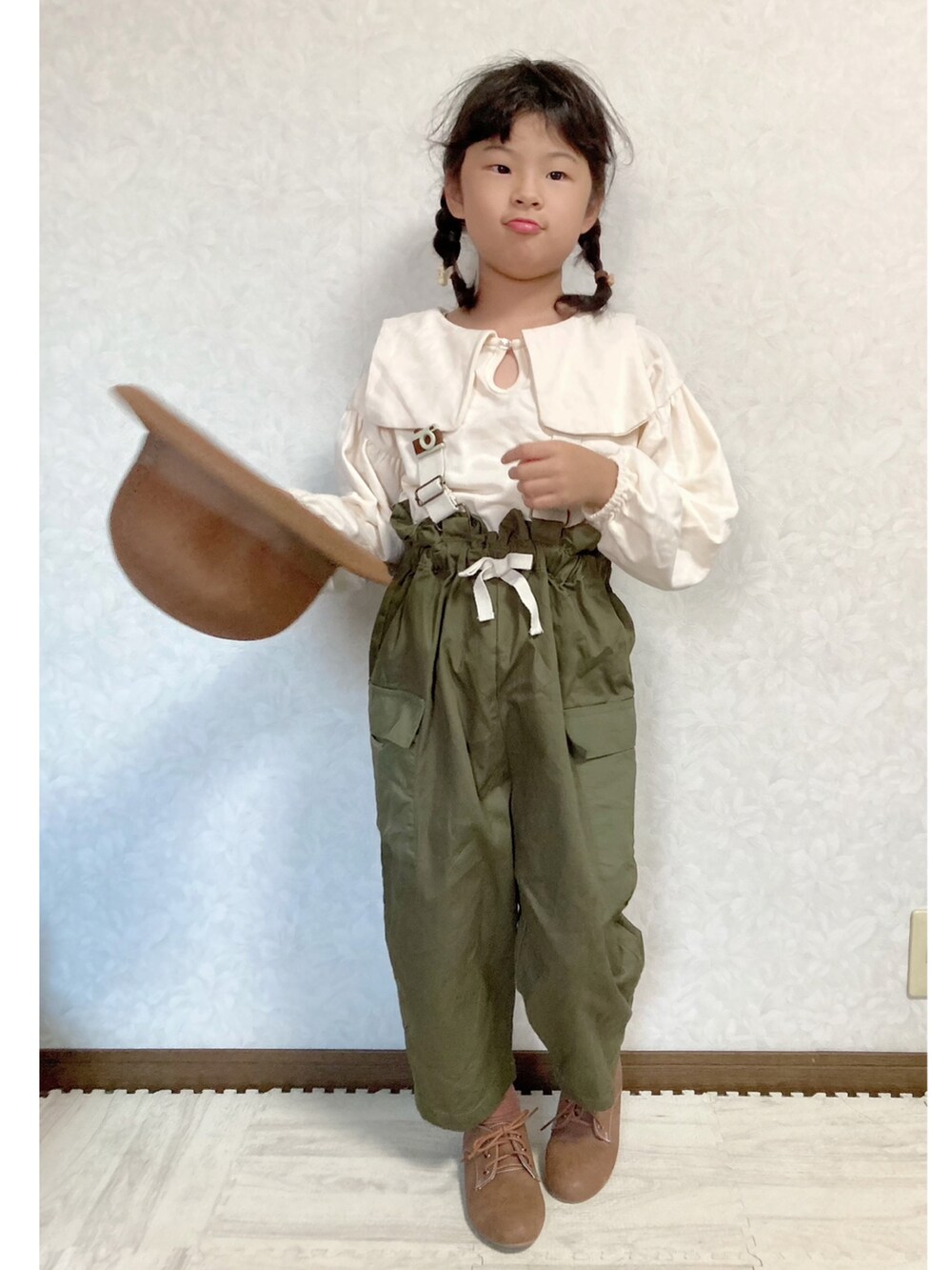 ホワイト系のスウェット、グリーン系のサロペット/オーバーオール、ブラウン系のドレスシューズを着用したキッズの秋コーディネートの4枚目の写真