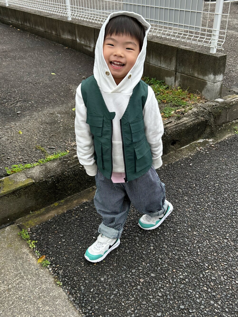 ピンク系のTシャツ/カットソー、ホワイト系のパーカー、グリーン系のベストを着用したキッズの春コーディネートの3枚目の写真