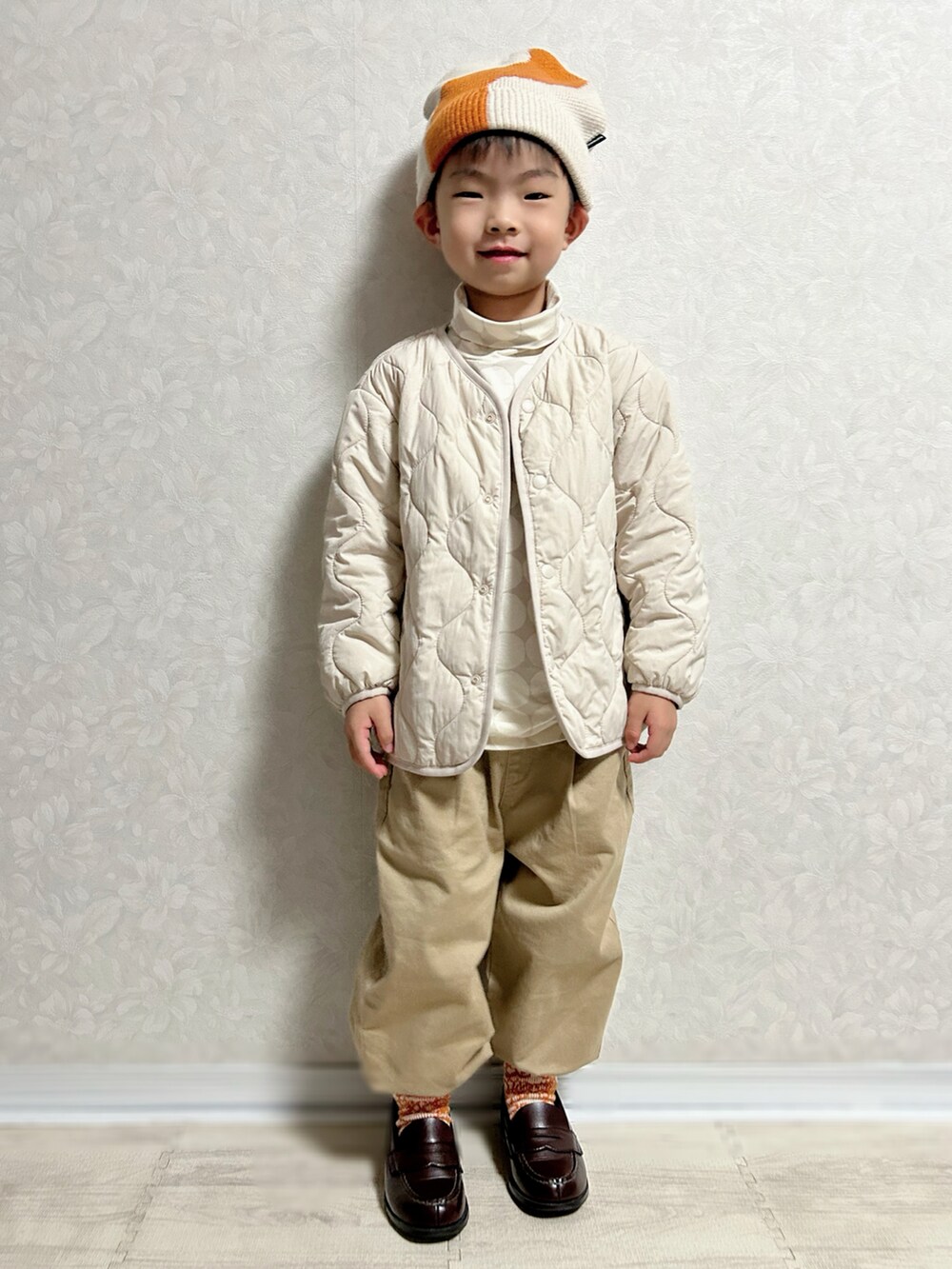 グレー系のTシャツ/カットソー、ホワイト系のノーカラージャケット、グリーン系のショルダーバッグを着用したキッズの秋コーディネートの3枚目の写真