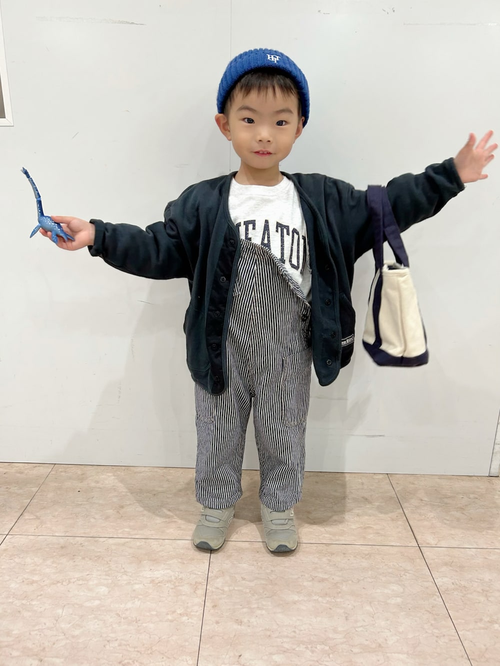 グレー系のスウェット、ブラック系のカーディガン/ボレロ、ホワイト系のショルダーバッグを着用したキッズの秋コーディネートの2枚目の写真