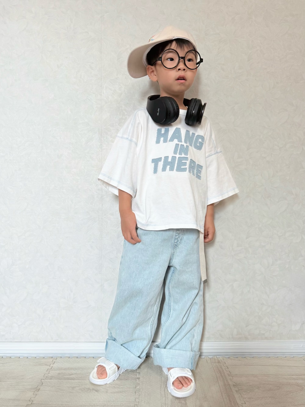 ホワイト系のTシャツ/カットソー、ブルー系のデニムパンツ、ホワイト系のサンダルを着用したキッズの夏コーディネートの2枚目の写真