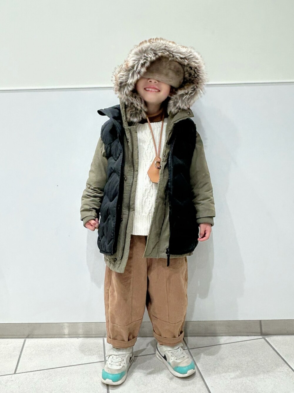 イエロー系のニット/セーター、ホワイト系のニット/セーター、グリーン系のモッズコートを着用したキッズの冬コーディネートの3枚目の写真