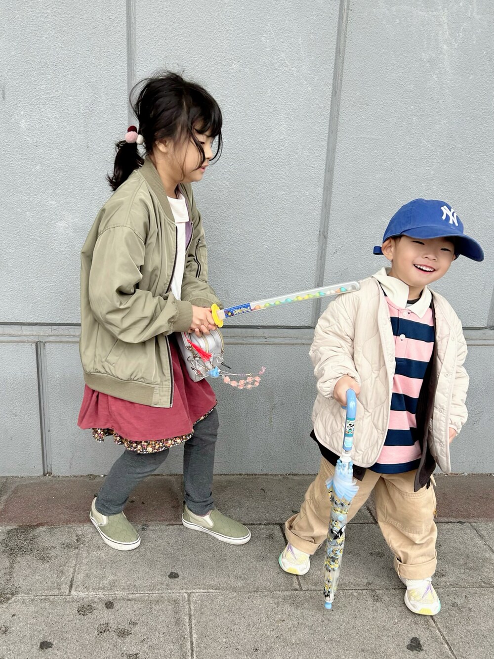 ピンク系のポロシャツ、ベージュ系のカーゴパンツ、ホワイト系のスニーカーを着用したキッズの春コーディネートの5枚目の写真