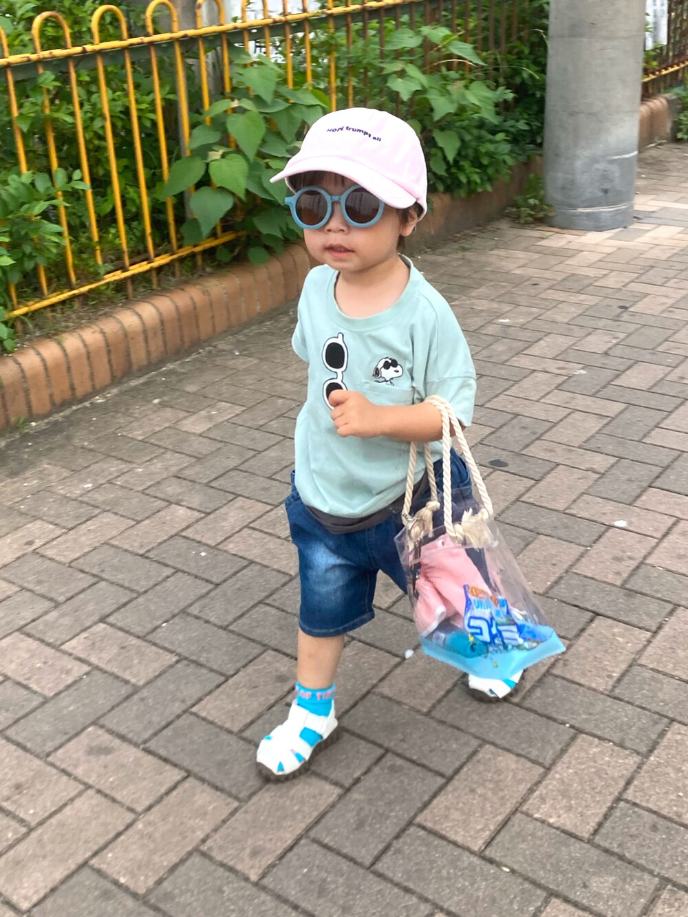 グリーン系のTシャツ/カットソー、ブルー系のデニムパンツ、ホワイト系のサンダルを着用したキッズの夏コーディネートの4枚目の写真