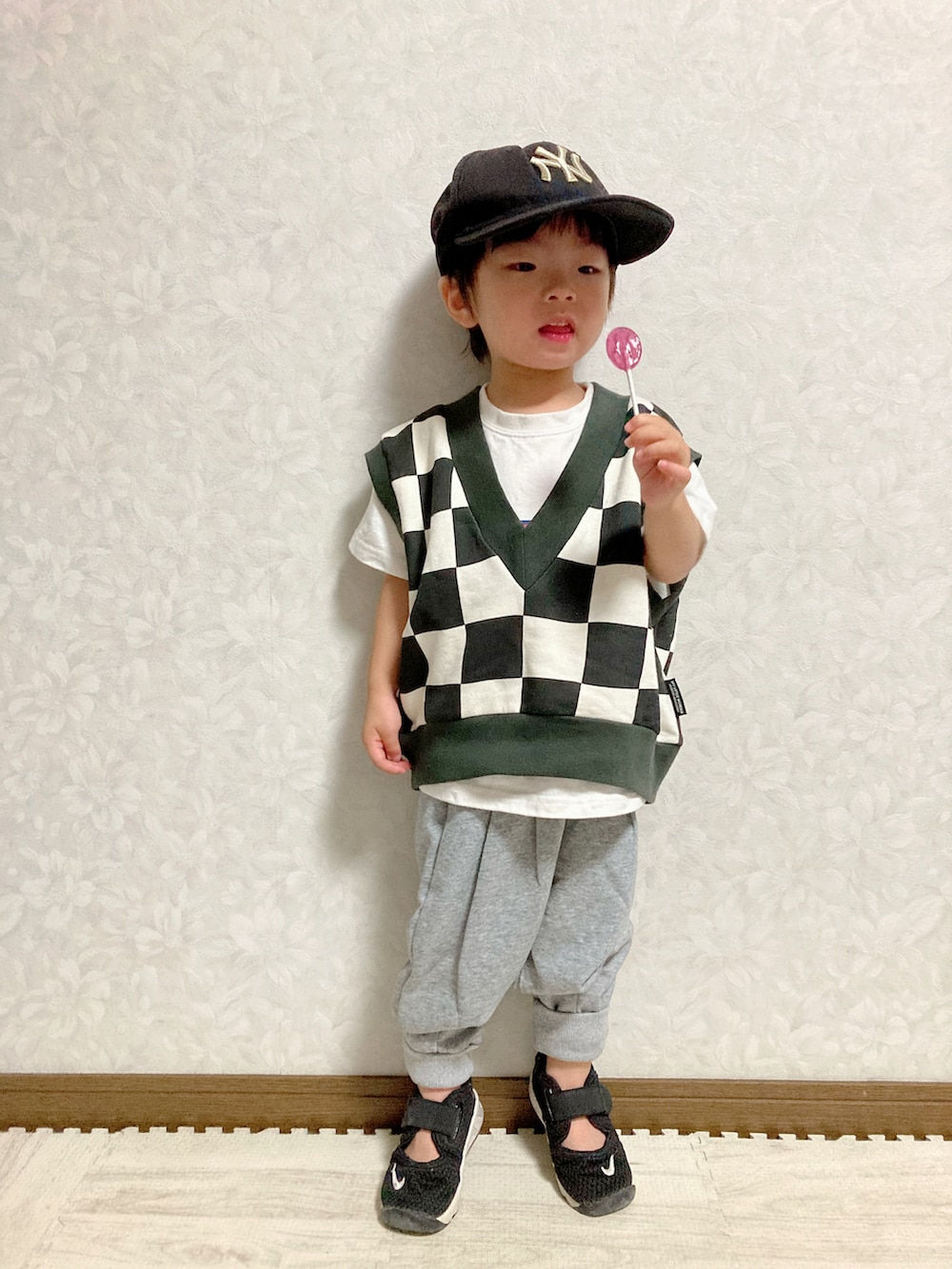 ホワイト系のTシャツ/カットソー、ブラック系のベスト、グレー系のスウェットパンツを着用したキッズの秋コーディネートの3枚目の写真
