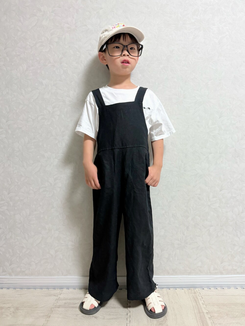 グリーン系のTシャツ/カットソー、ブラック系のサロペット/オーバーオール、ホワイト系のサンダルを着用したキッズの夏コーディネートの4枚目の写真
